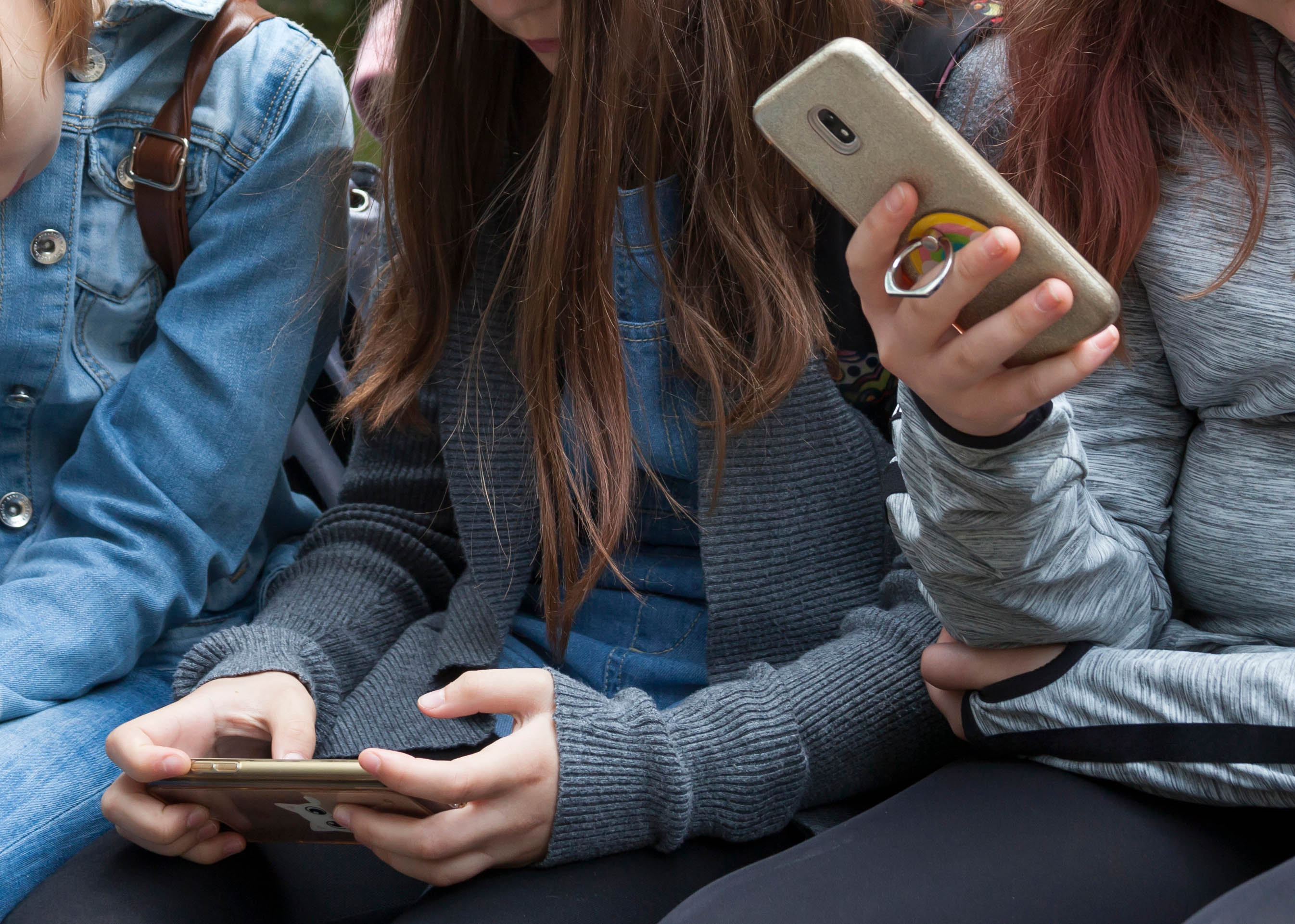 Bild på tre barn som håller i telefoner