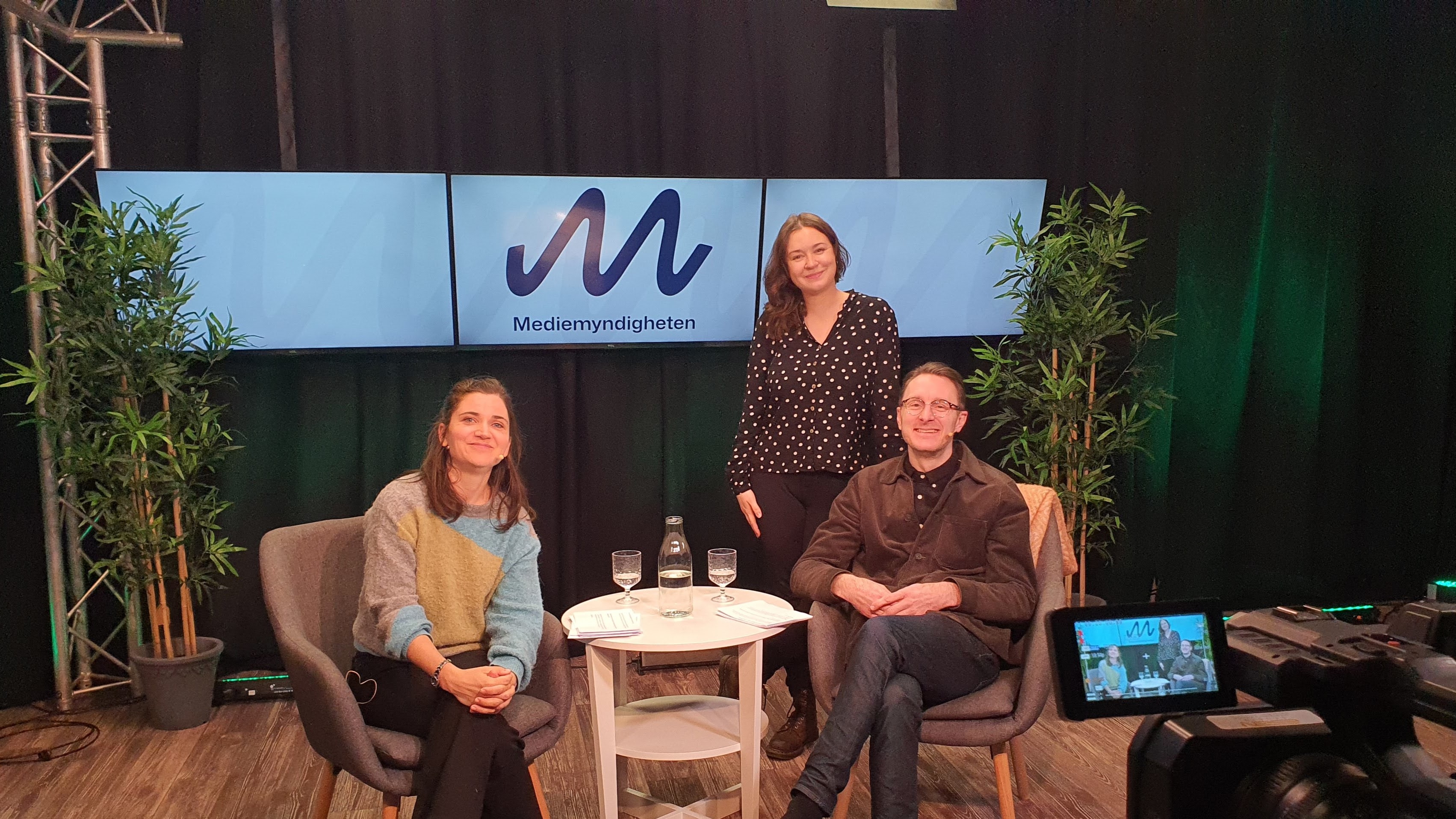 Två kvinnor och en man i en studio.
