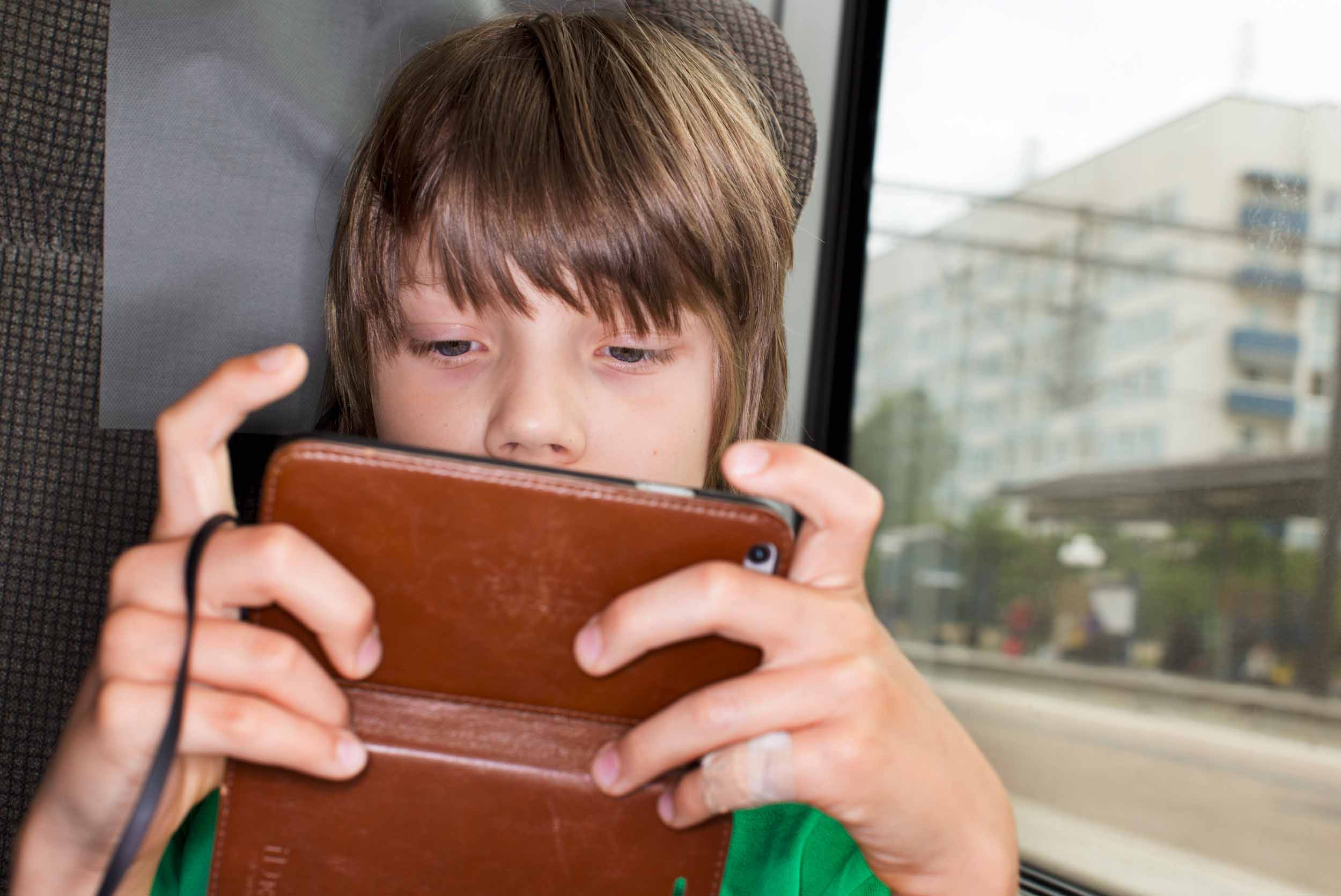 Pojke med telefon på tåg